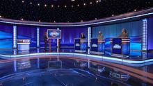 Host Ken Jennings and contestants Margaret Shelton, Caitlin Mchale, and Adrian Alcala are pictured on stage.