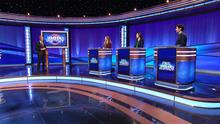 Ken Jennings and the contestants on the Jeopardy! stage.